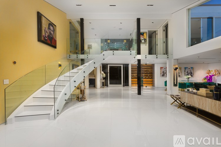 A spacious interior with a staircase and a painting on the wall.
