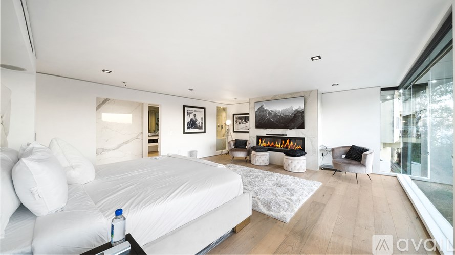 A bedroom with a large bed and a painting of a cartoon character on the wall.