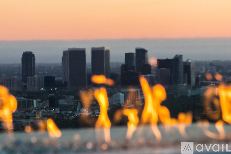 A city skyline at sunset with buildings silhouetted against the sky.