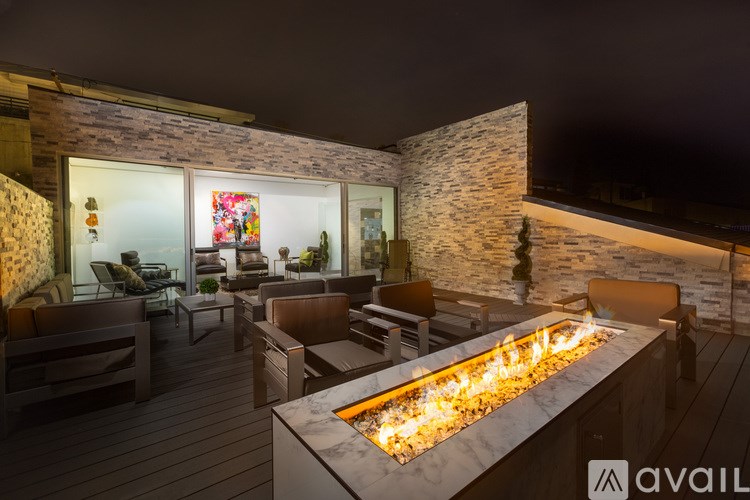 A modern outdoor seating area with a fire pit in the center.