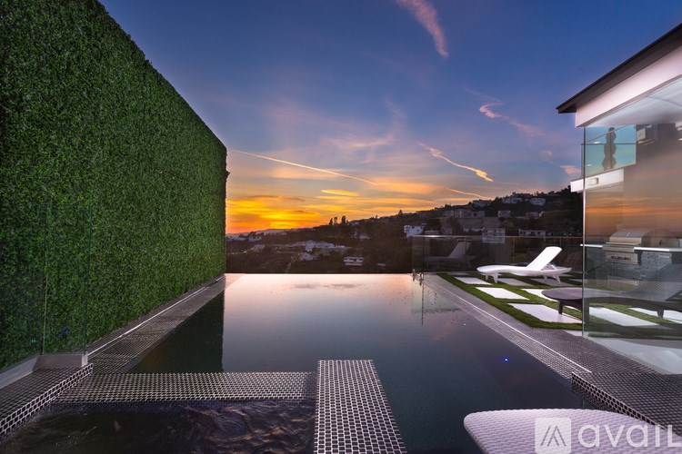 A modern house with a pool and a green wall.
