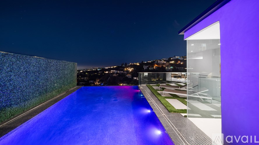 A modern building with a pool at night.