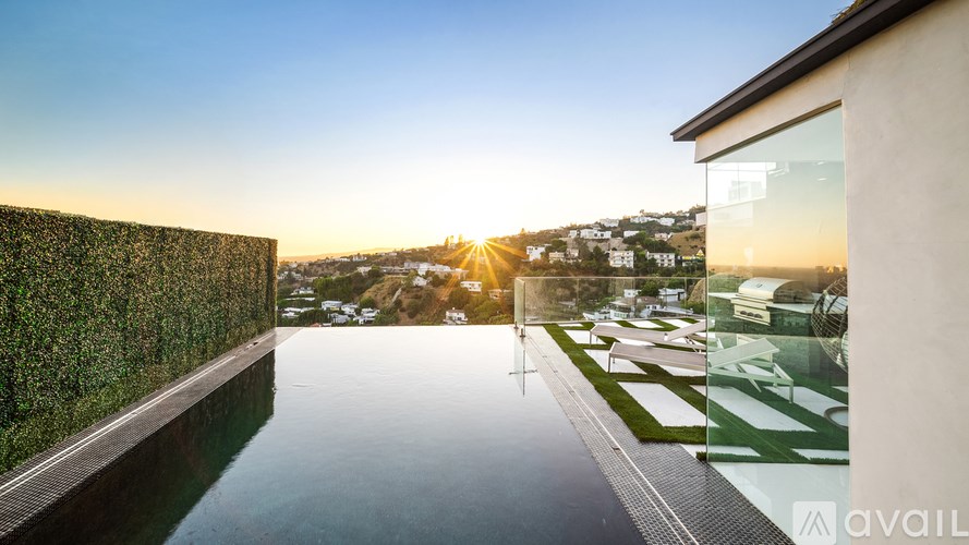 A modern building with a pool and a sunset view.