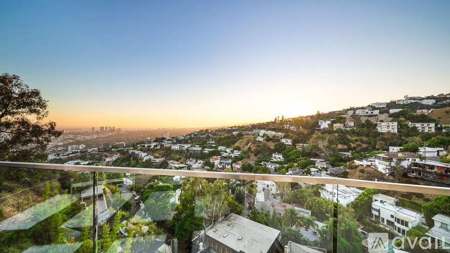 A sunset view from a balcony overlooking a residential area.