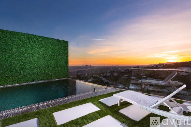 A modern building with a green wall and a pool.