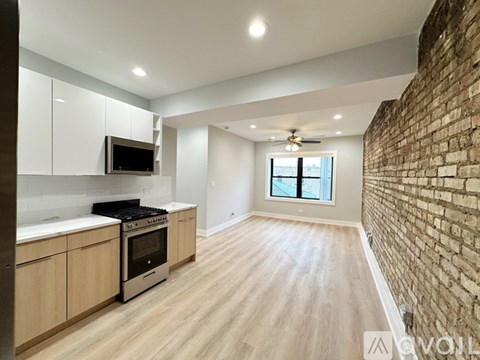 A kitchen with wooden floors and a brick wall.