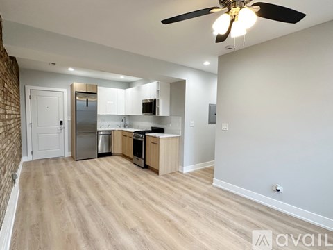 A kitchen with a refrigerator, microwave, oven, and sink is available for rent.