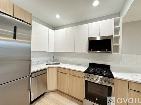 A modern kitchen with a stainless steel refrigerator and a stove top oven.