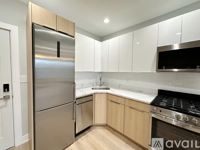 A modern kitchen with a stainless steel refrigerator and wooden cabinets.