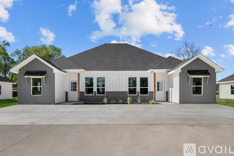 A modern house with a large front yard is available for purchase.