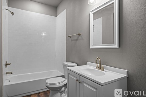 A white bathroom with a toilet, sink, and bathtub.