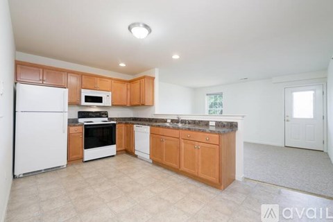 A kitchen with wooden cabinets and a white refrigerator.