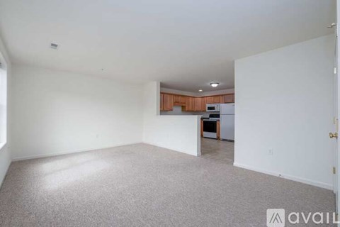 A large empty room with a carpeted floor and white walls.