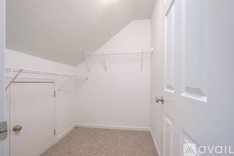 A room with a door and a carpeted floor.