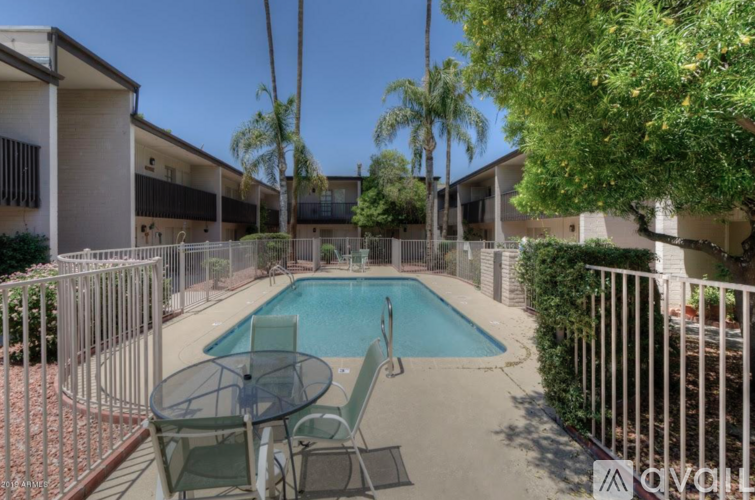 A pool surrounded by a table and chairs.
