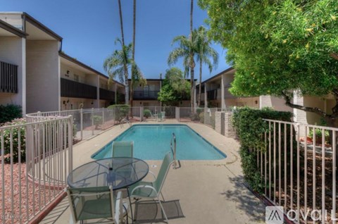 A pool surrounded by a table and chairs.