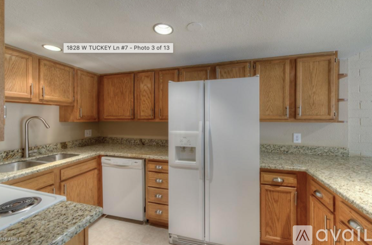 A kitchen with wooden cabinets and a white refrigerator.