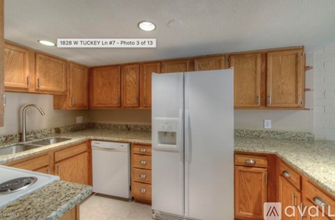 A kitchen with wooden cabinets and a white refrigerator.