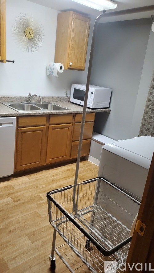 A kitchen with a wooden cabinet and a metal fridge.