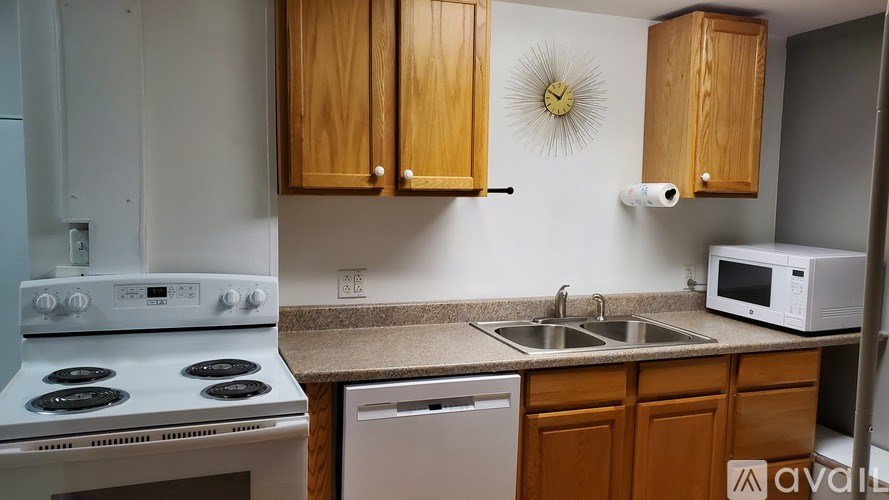 A kitchen with wooden cabinets and a white stove.