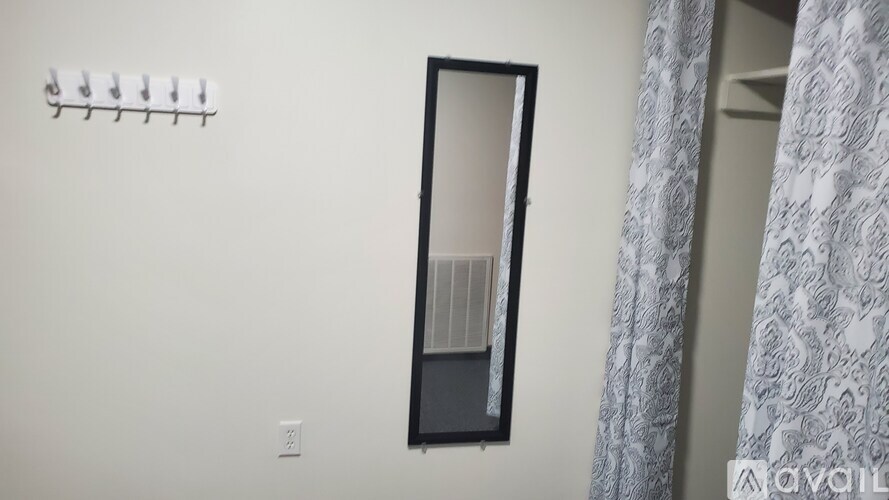 A mirror is hanging on the wall above a shelf.