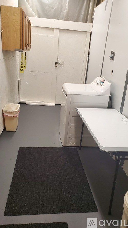 A bathroom with a toilet, sink, and trash can.
