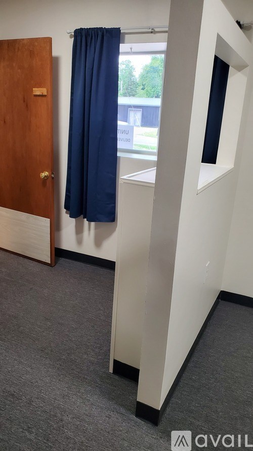 A room with a blue curtain and a wooden door.