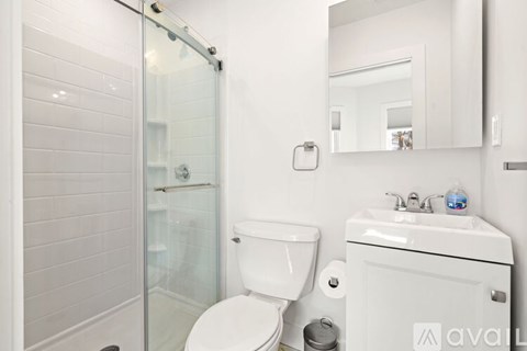 A white toilet sits next to a sink in a bathroom.