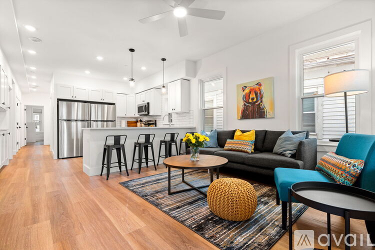 A living room with a black couch and a wooden coffee table.