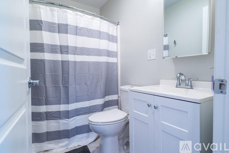 A bathroom with a toilet, sink, and shower curtain.