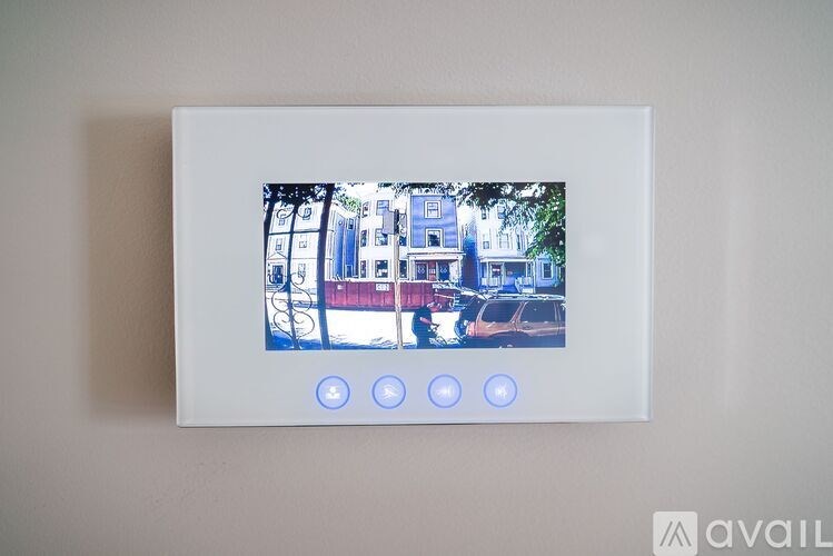 A picture of a building is displayed on a screen with four blue lights below it.