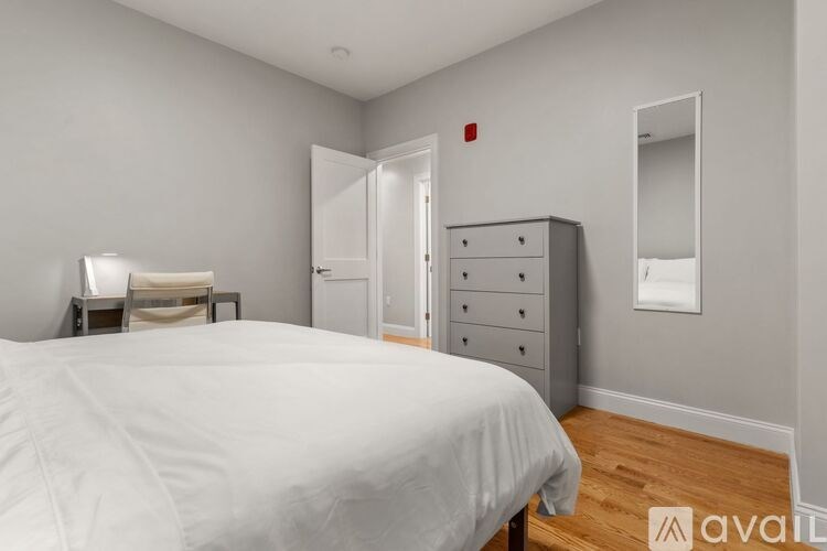 A bedroom with a large bed and a dresser.