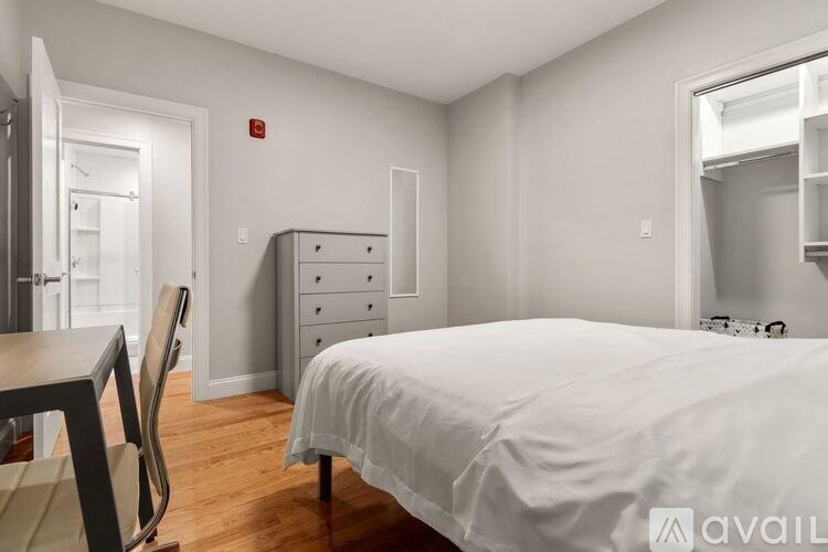 A bedroom with a bed, dresser, and chair.