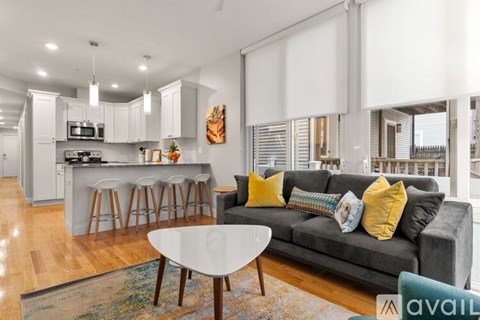 A modern living room with a grey couch and a white coffee table.