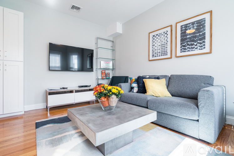 A grey couch with a coffee table in front of it.