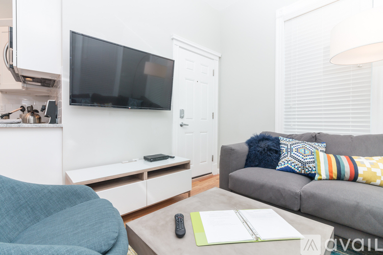 A living room with a grey couch and a television.