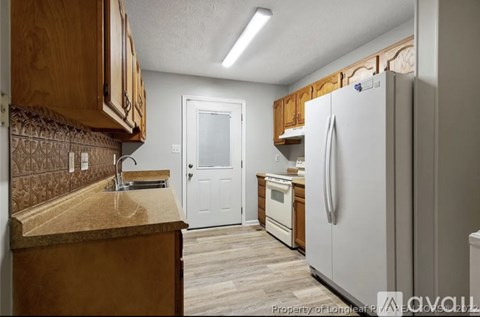 A kitchen with wooden cabinets and a white refrigerator.