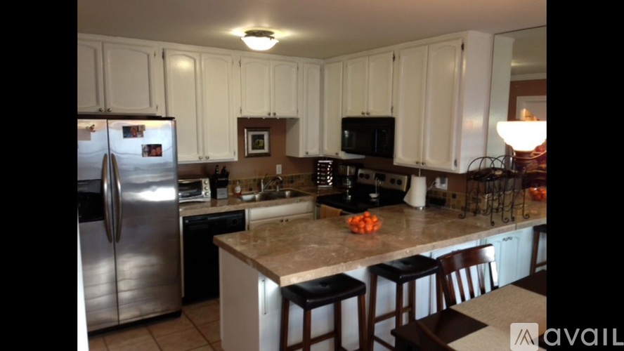 A kitchen with white cabinets and a granite countertop.