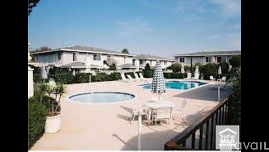 A pool and patio area with a tree and chairs.