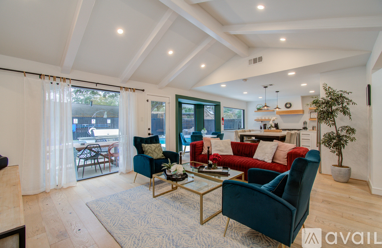 A living room with a blue chair and a red couch.