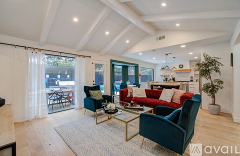 A living room with a blue chair and a red couch.