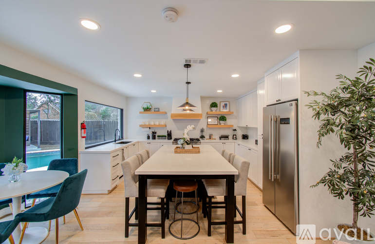 A modern kitchen with a dining table and chairs.