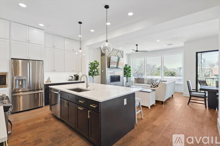 A modern kitchen with dark wood floors and stainless steel appliances.