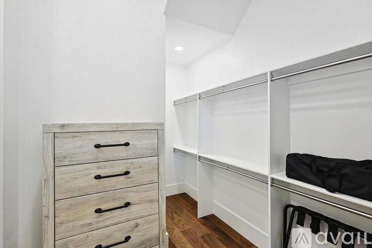 A white closet with a black bag hanging on a rail.