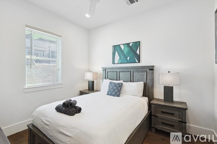 A bedroom with a bed, nightstand, and window.