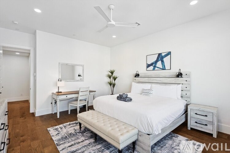 A bedroom with a bed, desk, and chair.