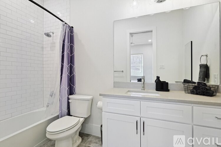 A white bathroom with a toilet, sink, and shower.