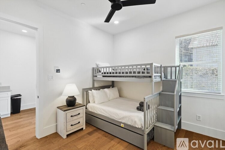 A bedroom with a bunk bed and a ceiling fan.