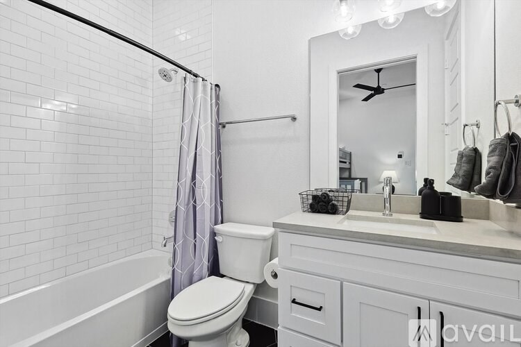 A white bathroom with a toilet, sink, and shower.