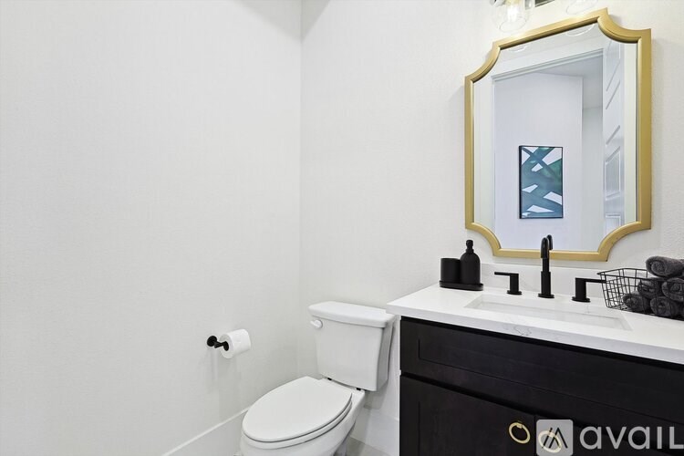 A bathroom with a toilet, sink, and mirror.